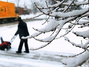 A homeowner uses a snow blower to clear his driveway in central Windsor on Feb. 8, 2013. (JASON KRYK/The Windsor Star)