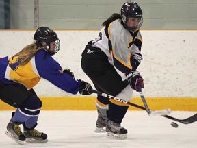 St. Anne's Taylor Reaume, left, and St. Joseph's Angeline Taiariol battle for the puck during Game 1 of their playoff series Tuesday, Feb. 12, 2013 at the Tecumseh Arena. (DAN JANISSE/The Windsor Star)