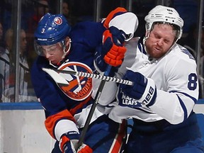 Toronto's Phil Kessel, right, hits Travis Hamonic of the New York Islanders in the first period at the Nassau Veterans Memorial Coliseum February 28, 2013 in Uniondale, N.Y. (Bruce Bennett/Getty Images)