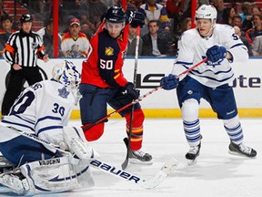 Toronto goaltender Ben Scrivens, left, stops a shot by Florida's Drew Shore, centre, at the BB&T Center Feb. 18, 2013 in Sunrise, Fla. (Joel Auerbach/Getty Images)