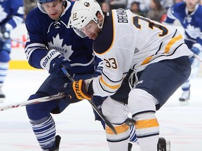 Toronto's Clarke MacArthur, left, battles with Buffalo's T.J. Brennan during NHL action at the Air Canada Centre Feb. 21, 2013 in Toronto. (Abelimages/Getty Images)