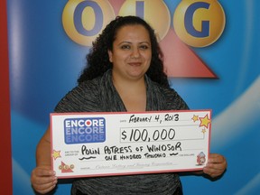 Windsor resident and lottery winner Polin Potress, 31, holds up the cheque for $100,000 she received through the Feb. 1 Encore draw. (Handout / The Windsor Star)