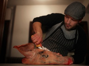 WINDSOR, ONT.:FEBRUARY 27, 2013 -- Jamie Waldron, executive butcher for Landmark Group, carves the cheek off the head of a Berkshire pig at a butcher demonstration dinner at Rino's Kitchen and Ale House, Wednesday, February 27, 2013. (DAX MELMER/The Windsor Star)