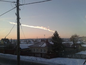 In this photo provided by E1.ru a meteorite contrail is seen over a vilage of Bolshoe Sidelnikovo 50 km of Chelyabinsk on Friday, Feb. 15, 2013. A meteor streaked across the sky of Russia’s Ural Mountains on Friday morning, causing sharp explosions and reportedly injuring around 100 people, including many hurt by broken glass. (AP Photo/ Nadezhda Luchinina, E1.ru)
