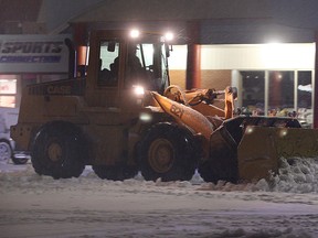 A snow removal driver cleans the Riverside Plaza in Windsor, Ont. Tuesday evening, Feb. 26, 2013, during a heavy snow.   (DAN JANISSE/The Windsor Star)