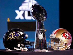 The Vince Lombardi trophy is displayed between helmets from the Baltimore Ravens, left, and the San Francisco 49ers who will meet for Super Bowl XLVII on Feb. 3, 2013. (Patrick Semansky/Associated Press)