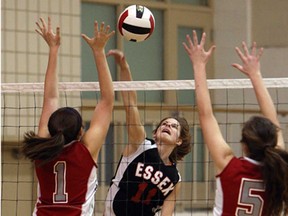 Essex's Cassie Robert, centre, spikes the ball through the Brennan's Mandy Johnstone, left, and Nicole Denomme during the WECSSAA girls AA volleyball semifinal in Essex Thursday, Feb. 14, 2013. Essex won 3-0 (25-17, 25-13, 25-17).(TYLER BROWNBRIDGE/The Windsor Star)