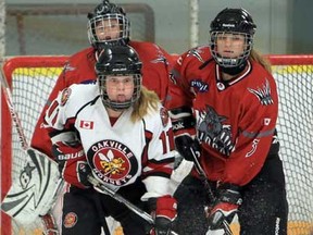 Oakville's Andrea Benac, centre,  fights for position with Southwest Wildcats  goaltender Hanna Slater, left, and Haley Telaga during hockey action at Forest Glade Arena Feb. 17, 2013.  The Hornets defeated the Wildcats 4-3.  (JASON KRYK/The Windsor Star)