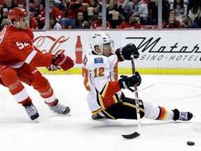 Detroit's Jonathan Ericsson, left, takes down Calgary's Jarome Iginla during the second period in Detroit Tuesday, Feb. 5, 2013. Detroit Red Wings goalie Jimmy Howard stopped Iginla on the ensuing penalty shot. (AP Photo/Paul Sancya)