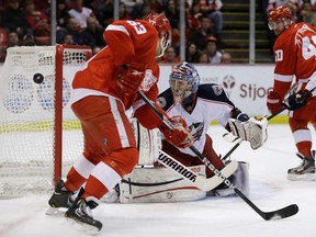 Blue Jackets goalie Sergei Bobrovsky, left, watches the puck pass Red Wings centre Joakim Andersson Thursday in Detroit. The Red Wings lost 3-2. (AP Photo/Carlos Osorio)