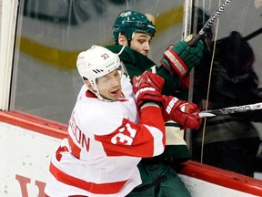 In this file photo, Minnesota defenceman Clayton Stoner, right, is checked by Detroit winger Mikael Samuelsson Sunday, Feb. 17, 2013, in St. Paul. (AP Photo/Paul Battaglia)