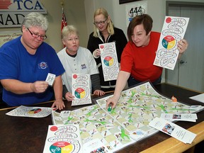 Cathy Reaume, left, Bernice Renaud, Terry Waymouth and Jennifer Jewell unveil a board game designed to attract girls to trades jobs at the CAW Local 444/200 hall in Windsor on Friday, March 15, 2013.                        (TYLER BROWNBRIDGE/The Windsor Star)