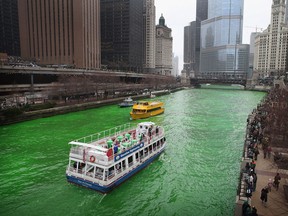 Tour boats travel the Chicago River after workers dyed it green to kick off the city's St. Patrick's day celebration on March 16, 2013 in Chicago, Ill. The dying of the river has been a tradition in the city for 43 years.  (Photo by Scott Olson/Getty Images)