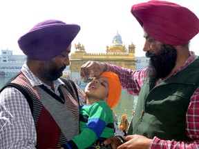 An Indian Sikh boy receives polio vaccination drops from a medical volunteer during an immunization drive outside the Golden Temple in Amritsar on February 24, 2013.  The number of polio cases worldwide reached a record low in 2012, giving experts confidence that the disease can finally be eradicated, according to presentations made November 2012 at a major U.S. conference.   (NARINDER NANU/AFP/Getty Images)