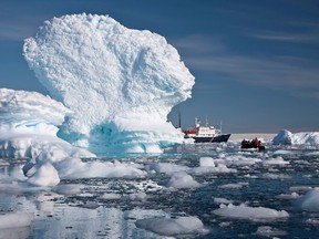 In this Dec. 2, 2009 photo provided by Aurora Expeditions, an inflatable boat carries tourists past an iceberg along the Antarctic Peninsula. In a remote, frozen, almost pristine land where the only human residents are involved in research, tourism comes with risks, for both the continent and the tourists. (AP Photo/Aurora Expeditions, Andrew Halsall)