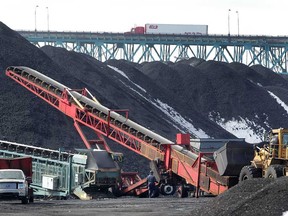 Huge piles of black material are being offloaded  at the Transflo Terminal in Detroit. The material is a petroleum coke product filtered out of crude oil by the nearby Marathon Oil refinery. (DAN JANISSE/The Windsor Star)