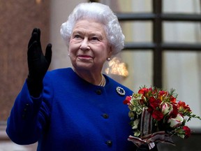 In this Tuesday, Dec. 18, 2012 file photo, Britain's Queen Elizabeth II looks up and waves to members of staff of The Foreign and Commonwealth Office as she ends an official visit which is part of her Jubilee celebrations in London. Queen Elizabeth has been taken to the King Edward VII hospital in central London suffering from gastroenteritis, Sunday, March 3, 2013. A palace spokesman said she was expected to stay in hospital for two days and all engagements for this week will be either postponed or cancelled.(AP Photo/Alastair Grant Pool, file)
