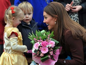 Britain's Catherine, Duchess of Cambridge, receives flowers from three-year old Isobelle Laursen, left, during her visit to Humberside Fire and Rescue Station in Grimsby, north Engalnd, Tuesday March 5, 2013. Her Royal Highness met many local people during her visit and people involved in a personal development course run by The Prince’s Trust and delivered in partnership with Humberside Fire and Rescue Service. (AP Photo / Owen Humphreys)