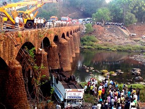 Rescuers and others gather at the site of a bus accident in Ratnagiri district, in the western Indian state of Maharashtra, Tuesday, March 19, 2013. The bus packed with passengers crashed through a guard rail and fell off a bridge in western India early Tuesday, killing at least 37 people and injuring another 15, police said. (AP Photo)