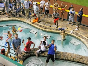 This July 11, 2011 file photo shows a home-run ball falls into the pool during baseball' All-Star Home Run Derby at Chase Field in Phoenix. All the baseball teams are based in major U.S. cities and many of the stadiums are situated in bustling downtown areas with engrossing things to do and savory places to eat when you aren't attending a game. These attractions should help the cause of baseball fans trying to recruit a spouse or other traveling teammates who may not appreciate the sublime pleasures of the game. (AP Photo/The Arizona Republic, Rob Schumacher)