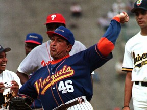 In this Feb. 25, 1999 file photo, Venezuela's President Hugo Chavez, wearing the national baseball team uniform, pitches to Chicago Cubs out fielder Sammy Sosa during a batting exhibition at Universtity Stadium in Caracas, Venezuela. Venezuela's Vice President Nicolas Maduro announced on Tuesday, March 5, 2013 that Chavez has died. Chavez, 58, was first diagnosed with cancer in June 2011. (AP Photo/Andres Leighton, File)