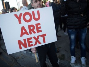 A demonstrator holds a banner reading "You are next" outside the parliament during a protest against bank deposit tax plans in Nicosia, Cyprus, on Tuesday, March 19, 2013. Euro-area finance ministers told Cyprus to raise 5.8 billion euros ($7.5 billion) from bank depositors to unlock emergency loans, maintaining the revenue target while suggesting sparing small-scale savers. Photographer: Simon Dawson/Bloomberg