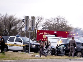 Emergency personnel are on the scene of a crash and shootout with police involving the driver of a black Cadillac with Colorado plates in Decatur, Texas, Thursday, March 21, 2013. The driver led police on a gunfire-filled chase through rural Montague County, crashed his car into a truck in Decatur, opened fire on authorities and was shot, officials said. Texas authorities are checking whether the Cadillac is the same car spotted near the home of Colorado prisons chief Tom Clements, who was shot and killed when he answered the door Tuesday night. (AP Photo/Wise County Messenger, Jimmy Alford)