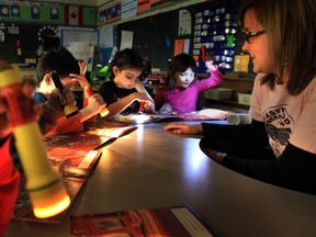 Eastwood Public School grade one students use flashlights to read during an hour of darkness in preparation for the upcoming Earth Hour. The school participated in activities that included a reduction in lights and electricity, a tour of the Chevrolet Volt from ENWIN Utilities, and a demonstration of solar energy with a City of Windsor solar-powered people mover. (JASON KRYK/The Windsor Star)