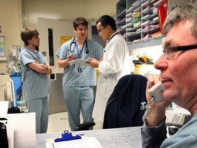 Dr. David Ng, centre, discusses a patient's chart with med student Jordan Vanderende, left, and 3rd-year medical student Tom Jordan as RN Pauil Gleason, right, converses by phone at Hotel-Dieu Grace Hospital emergency room Thursday March 14, 2013. (NICK BRANCACCIO/The Windsor Star)