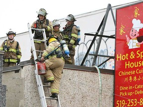 Firefighters climb on the roof of the Hot and Spicy House in Windsor, Ont. on Thursday, March 7, 2013. A fire damaged the roof but left the inside without any major damage. No one was injured in the blaze.                    (TYLER BROWNBRIDGE/The Windsor Star)