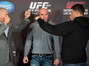 UFC President Dana White stands between Georges St-Pierre, left, and Nick Diaz, right, as they square off following their news conference in Montreal, Thursday, March 14, 2013, ahead of their UFC 158 title fight which takes place in Montreal on Saturday March 16. THE CANADIAN PRESS/Graham Hughes.