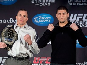 In this file photo, Welterweight UFC Champion Georges St-Pierre, left, and Nick Diaz flex their muscles during a news conference Wednesday, January 23, 2013 in Montreal. THE CANADIAN PRESS/Paul Chiasson