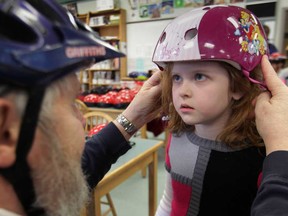 Charles Griffith, a volunteer with the local Brain Injury Association, helps Paige Rosebush, 7, get fitted for a helmet. 
(Windsor Star files)