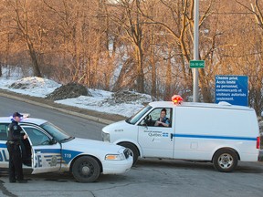 Police vehicles block the road leading to a detention centre in St. Jerome, Que., Sunday, March 17, 2013, where two prisoners made a daring escape by helicopter. THE CANADIAN PRESS/Graham Hughes