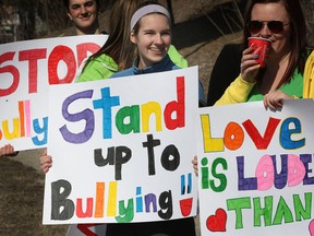 About two dozen protesters waved signs outside the Catholic school board Friday, March 8, 2013, in support of a gay student who says she was bullied by a teacher. Brooke Mulligan, 18, has alleged a religion teacher at St. Thomas of Villanova mistreated her because of her sexual orientation. Brooke Mulligan (C) is pictured during the protest. (DAN JANISSE/The Windsor Star)