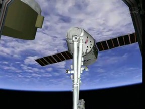 This frame grab made available by NASA TV shows a view of the SpaceX Dragon capsule on the end of the International Space Station's robotic arm, Sunday, March 3, 2013. SpaceX, the California-based company founded by billionaire Elon Musk, had to struggle with the Dragon following its launch Friday from Cape Canaveral. The spacecraft is delivering more than 1 ton of supplies to the the International Space Station. (AP Photo/NASA TV)