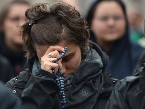 A faithful prays on St Peter's square, waiting for the smoke announcing the result of the second vote of the conclave on March 13, 2013 at the Vatican. Black smoke again billowed out of a chimney over the Vatican on Wednesday, indicating that cardinals meeting in a conclave have failed to choose a pope after three votes. AFP PHOTO / GABRIEL BOUYS