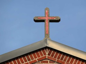 The Christian cross sits atop the Saint Angela Merici Church in Windsor, Ont.,  Sunday, March 10, 2013.  (DAX MELMER/The Windsor Star)
