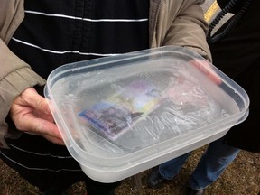 Protesters carrying a block of ice with $10.25 frozen inside descended on Windsor-West MPP Teresa Piruzza's office Friday morning to protest the minimum wage freeze. (Twitpic: Tyler Brownbridge/The Windsor Star)