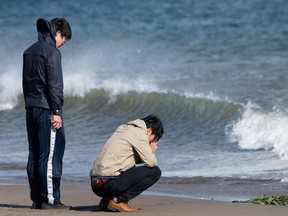 People pray on the second anniversary of the Great East Japan Earthquake and Tsunami at a coast damaged by the disaster in Sendai, Miyagi Prefecture, Japan, on Monday, March 11, 2013. Two years after a record earthquake devastated Japan's northeast, Prime Minister Shinzo Abe has driven the nation's bond risk to levels from before the disaster with a plan that will add to the world's biggest debt burden. Photographer: Kiyoshi Ota/Bloomberg