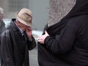 Robert Mahon, 66, is shielded from the media as he walks away from Superior Court in Windsor, Ont., Monday March 11, 2013. (NICK BRANCACCIO/The Windsor Star)