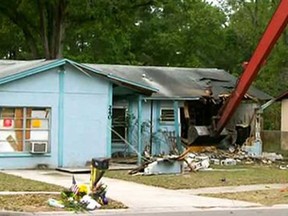 Crews with heavy equipment on Sunday, March 3, 2013, began the demolition of a Florida home over a huge sinkhole where a man is presumed dead after being swallowed by the earth three days ago. (Screengrab)