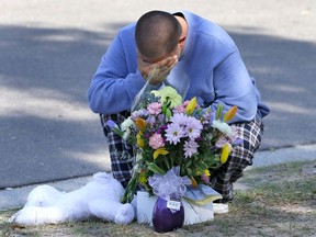 Jeremy Bush places flowers and a stuffed animal at a makeshift memorial in front of a home where a sinkhole opened up underneath a bedroom late Thursday evening and swallowed his brother Jeffrey in Seffner, Fla. on Saturday, March 2, 2013. Jeffrey Bush, 37, was in his bedroom Thursday night when the earth opened and took him and everything else in his room. Five other people were in the house but managed to escape unharmed. Bush's brother jumped into the hole to try to help, but he had to be rescued himself by a sheriff's deputy. (AP Photo/Chris O'Meara)