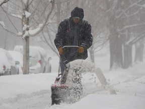 A maintenance man uses a snowblower to clear a sidewalk in Denver as a spring storm packing high winds and heavy snow swept over Colorado's Front Range and on to the eastern plains on Saturday, March 23, 2013. Forecasters predict up to a foot of snow will fall in some locations in Colorado before the storm heads toward the nation's midsection. (AP Photo/David Zalubowski)