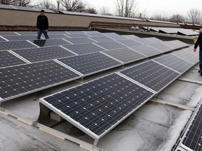 OYA Solar Inc. system designers Giovanni Cristofanilli, right, and Matthew Marentette inspect part of their roof-top Feed-in-Tariff (FIT) project installed on a Peter Street plant, March 6, 2013. (NICK BRANCACCIO/The Windsor Star)
