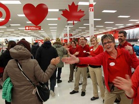 Employees welcome the first shoppers who lined up for the new Target store in in Guelph, Ont. on Tuesday March 5, 2013. The company is expected to open between 125 and 135 locations in Canada. (THE CANADIAN PRESS/Dave Chidley)