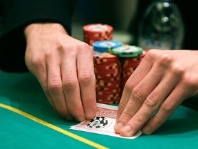 A player checks his hand during a game of Texas Hold 'em at the poker room in Caesar's Palace, Wednesday, Feb. 27, 2013, in Las Vegas. Poker has never been a big moneymaker like slot machines or roulette. In Sin City, epicenter of the poker craze, at least eight rooms have folded in the past two years. The trend is also playing out in Mississippi riverboats, Indian casinos and gambling halls near big cities from California to Florida. (AP Photo/Julie Jacobson)