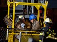 A worker, with black fire helmet at left inside a construction transport bucket, is rescued from an MTA subway construction project in New York early Wednesday, March 20, 2013 after being trapped up to his chest in debris for several hours. Fire officials say he is awake and conscious and is being evaluated at a local hospital. (AP Photo/Craig Ruttle)