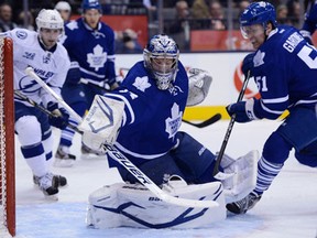 Toronto goaltender James Reimer, centre, makes a save with teammate Jake Gardiner, right, and Tampa Bay's Tom Pyatt looking on Wednesday. (THE CANADIAN PRESS/Frank Gunn)