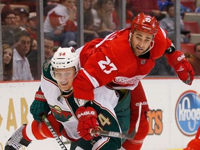 Detroit's Kyle Quincey, right, is checked by Minnesota's Mikael Granlund at Joe Louis Arena. (Photo by Gregory Shamus/Getty Images)